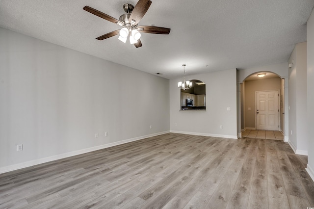 5801 Oyster Catcher Dr Unit 1022, North Myrtle Beach, SC 29582 - unfurnished living room featuring arched walkways, light wood-style flooring, a ceiling fan, a textured ceiling, and a chandelier