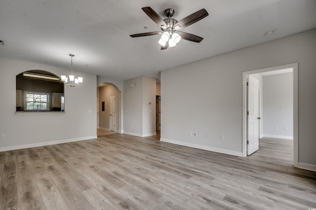 unfurnished living room with ceiling fan with notable chandelier, a textured ceiling, and light wood-type flooring