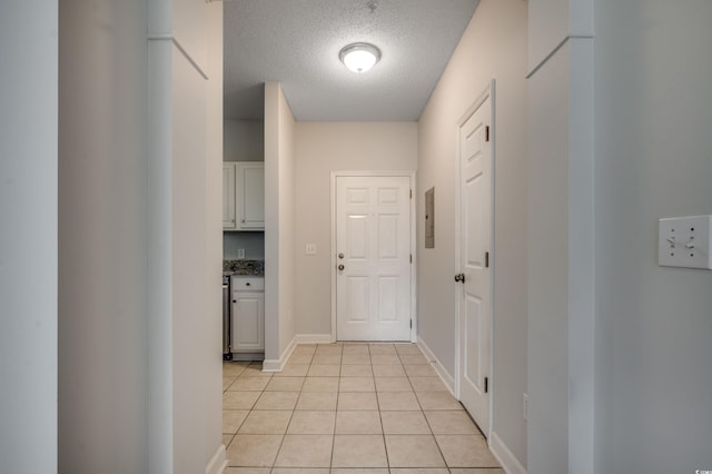 hallway with light tile patterned flooring and a textured ceiling