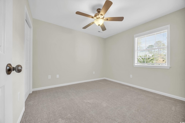 carpeted spare room with ceiling fan