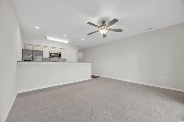 unfurnished living room featuring ceiling fan and carpet floors