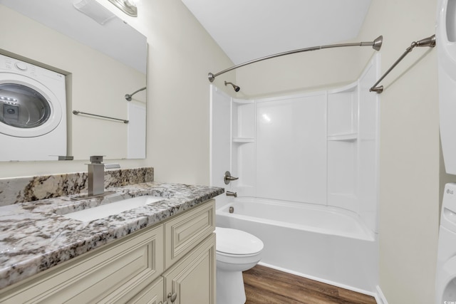 full bathroom featuring toilet, hardwood / wood-style floors, washer / clothes dryer, tub / shower combination, and vanity