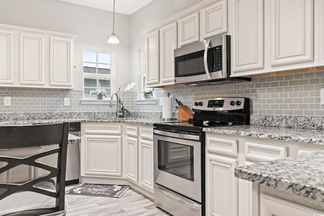 kitchen featuring backsplash, stainless steel appliances, sink, and white cabinets