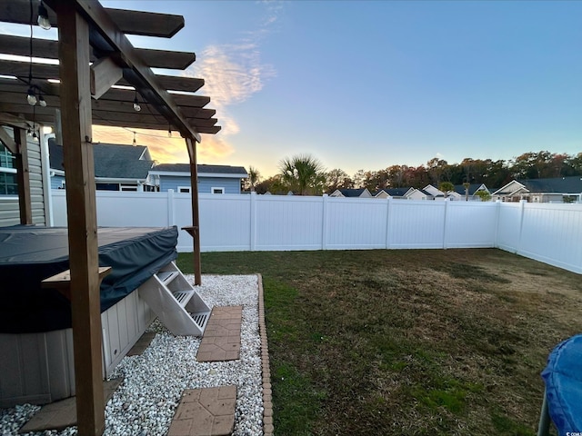 yard at dusk featuring a pergola