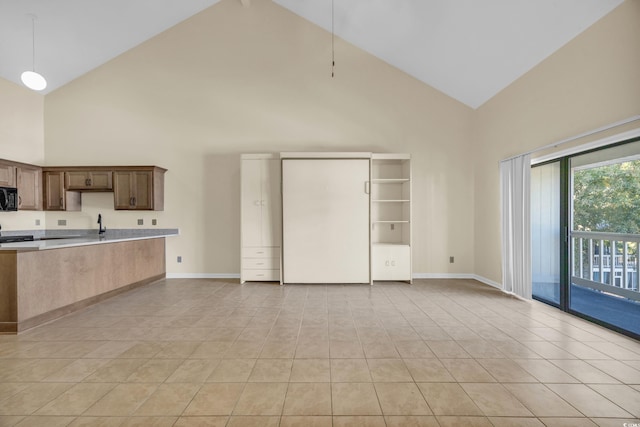 kitchen featuring light tile patterned floors, decorative light fixtures, and high vaulted ceiling