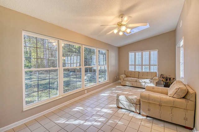 tiled living room featuring ceiling fan, a textured ceiling, and a wealth of natural light