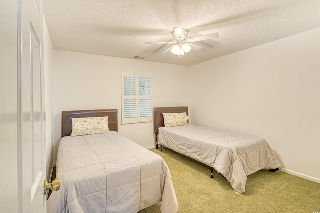 carpeted bedroom featuring ceiling fan and a textured ceiling