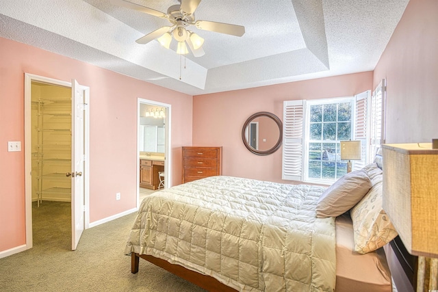 bedroom with light carpet, a walk in closet, ensuite bath, ceiling fan, and a closet