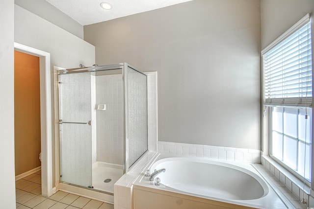 bathroom featuring tile patterned flooring, plenty of natural light, shower with separate bathtub, and a textured ceiling