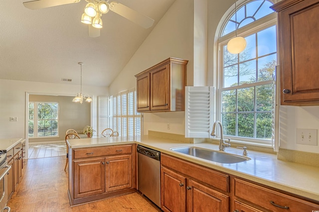 kitchen with kitchen peninsula, appliances with stainless steel finishes, light wood-type flooring, sink, and lofted ceiling