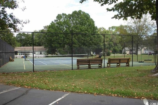 view of sport court with a lawn