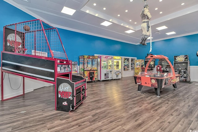 game room featuring a raised ceiling, crown molding, and wood finished floors