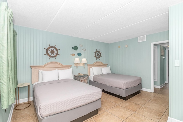 bedroom with light tile patterned floors, baseboards, and visible vents