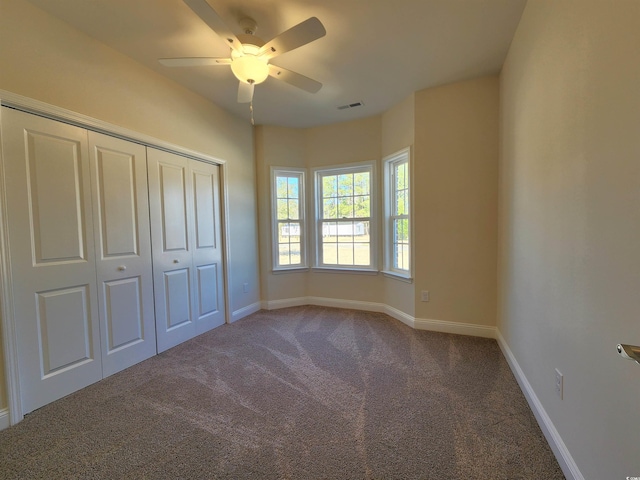 unfurnished bedroom featuring carpet, ceiling fan, and a closet