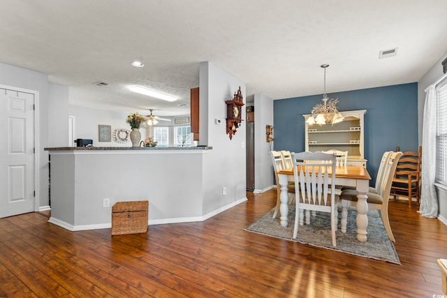 dining space featuring dark hardwood / wood-style floors and ceiling fan with notable chandelier