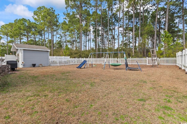 view of yard with a storage shed and a playground