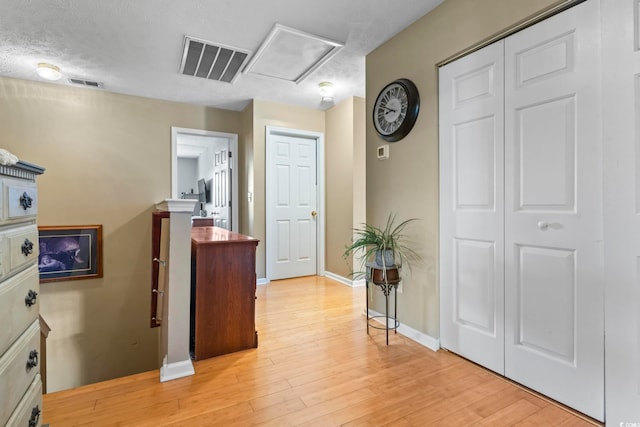 hall featuring a textured ceiling and light wood-type flooring