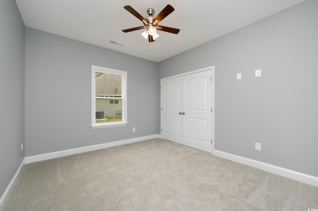 carpeted spare room featuring ceiling fan