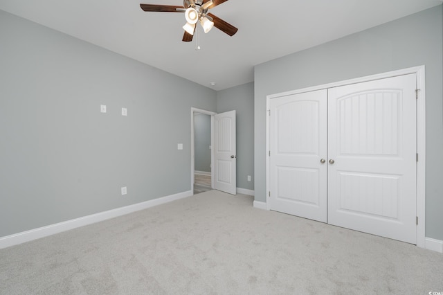 unfurnished bedroom featuring ceiling fan, a closet, and light colored carpet