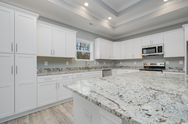 kitchen featuring light stone counters, white cabinetry, crown molding, and appliances with stainless steel finishes