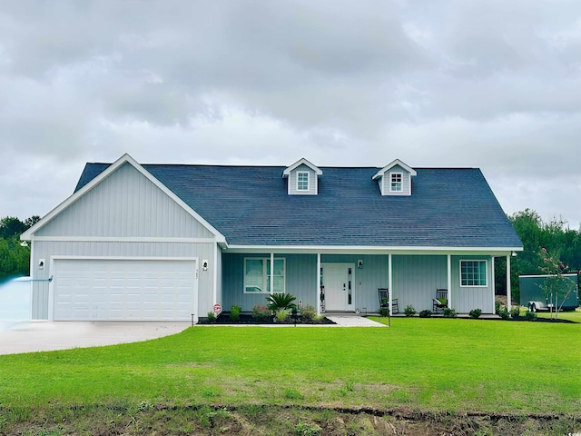 view of front of home with covered porch, a garage, and a front lawn