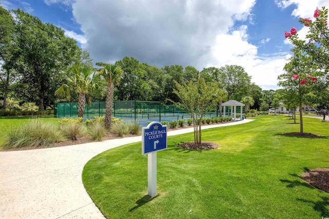 view of property's community featuring a gazebo, tennis court, and a yard