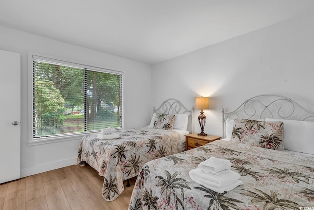 bedroom featuring multiple windows and light hardwood / wood-style flooring