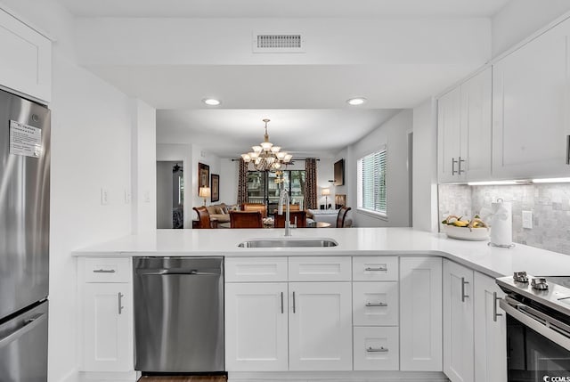 101 Westhill Cir Unit 5-C, Myrtle Beach, SC 29572 - kitchen with appliances with stainless steel finishes, a chandelier, a peninsula, light countertops, and decorative backsplash
