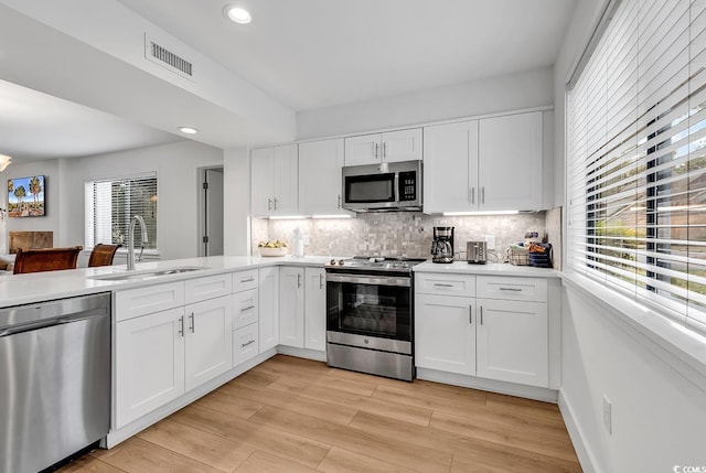 kitchen with plenty of natural light, white cabinetry, and stainless steel appliances