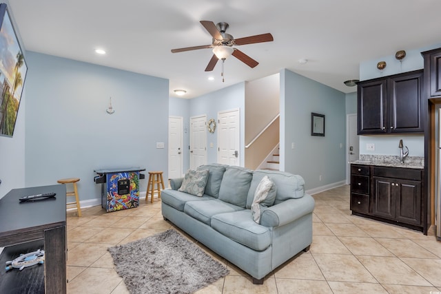 tiled living room with ceiling fan and sink