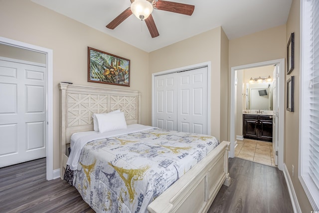 bedroom with dark hardwood / wood-style floors, connected bathroom, ceiling fan, and a closet