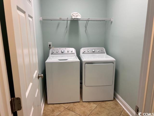 clothes washing area with separate washer and dryer and light tile patterned flooring