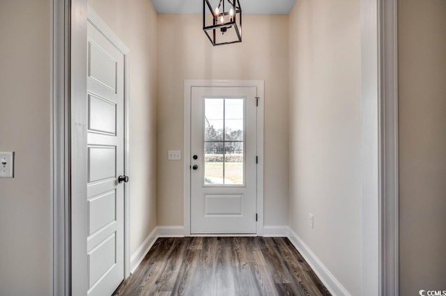 entryway with an inviting chandelier and dark wood-type flooring