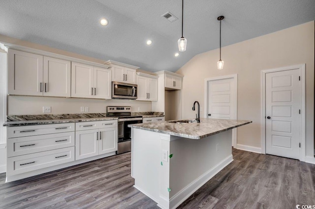 kitchen featuring pendant lighting, lofted ceiling, white cabinets, sink, and stainless steel appliances