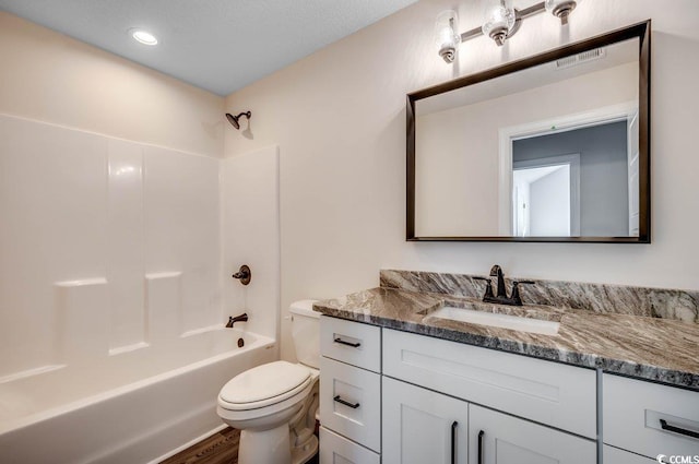 full bathroom with toilet, hardwood / wood-style floors, vanity, and bathing tub / shower combination