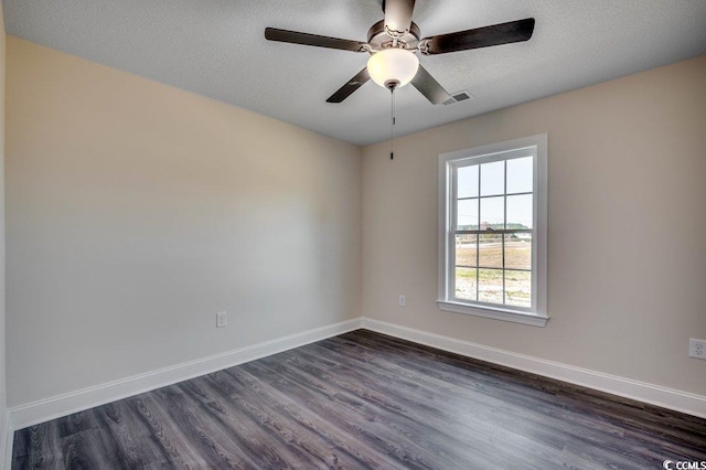 spare room with a textured ceiling, ceiling fan, and dark hardwood / wood-style floors