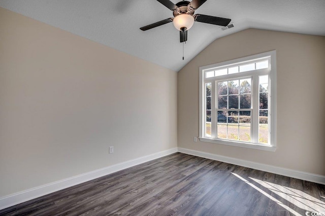 spare room featuring a textured ceiling, ceiling fan, dark wood-type flooring, and vaulted ceiling