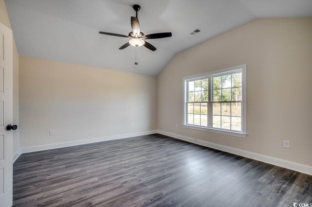 empty room with dark hardwood / wood-style floors, ceiling fan, and vaulted ceiling