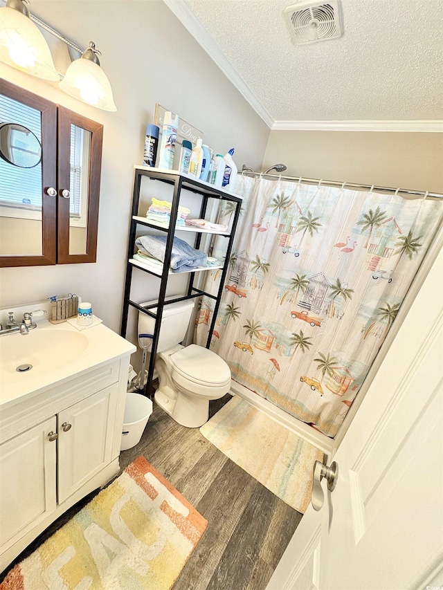 bathroom featuring vanity, hardwood / wood-style flooring, toilet, ornamental molding, and a textured ceiling