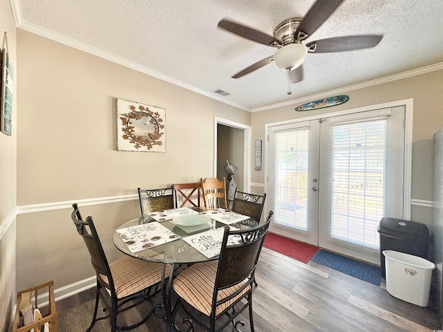 dining room featuring crown molding, french doors, wood-type flooring, and a textured ceiling