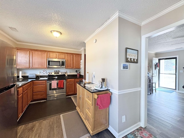 100 Dorman Cir, Myrtle Beach, SC 29577 - kitchen featuring appliances with stainless steel finishes, a textured ceiling, dark wood finished floors, dark countertops, and ornamental molding