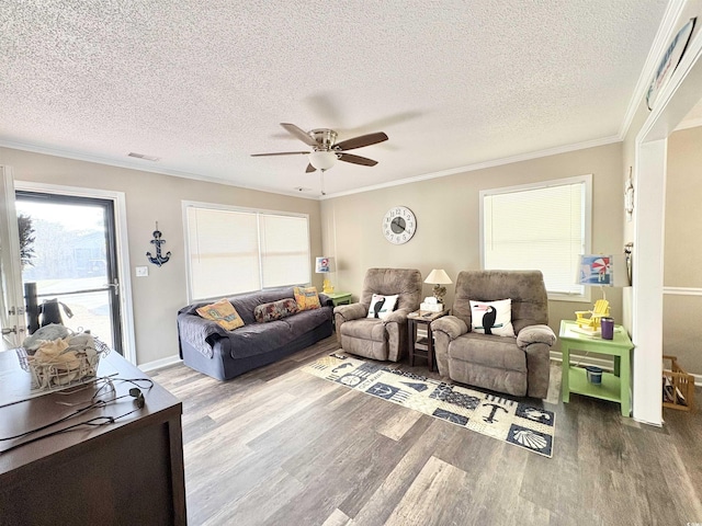 living room with a textured ceiling, hardwood / wood-style flooring, and ornamental molding