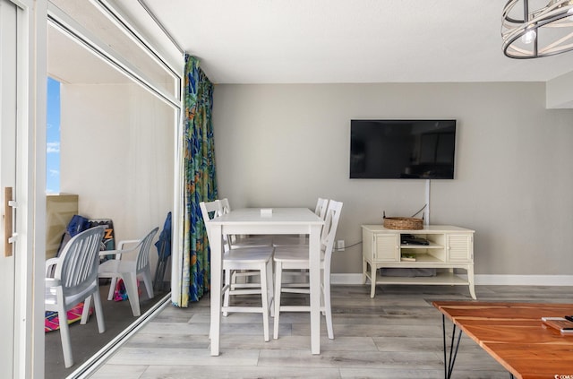 dining area featuring wood-type flooring and an inviting chandelier