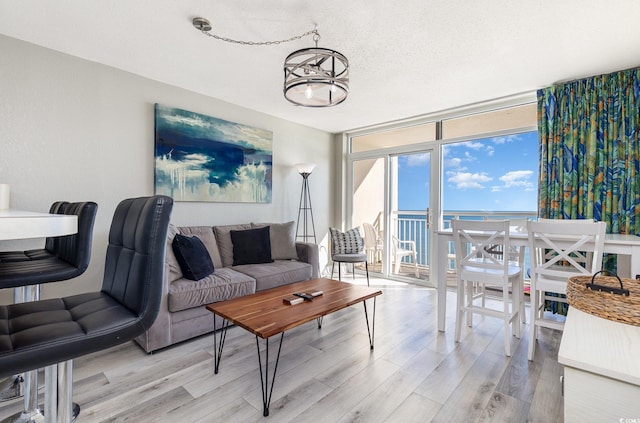 2701 S Ocean Blvd Unit 1808, North Myrtle Beach, SC 29582 - living room featuring floor to ceiling windows, light wood-style floors, and a textured ceiling