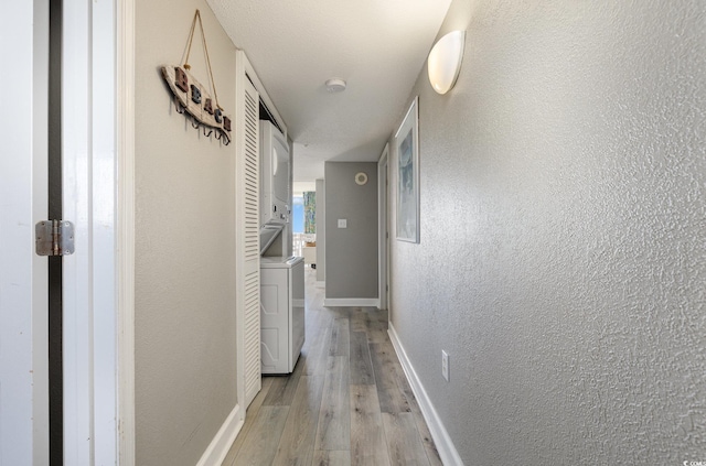 2701 S Ocean Blvd Unit 1808, North Myrtle Beach, SC 29582 - hall featuring stacked washer / drying machine, light wood-style flooring, and a textured wall