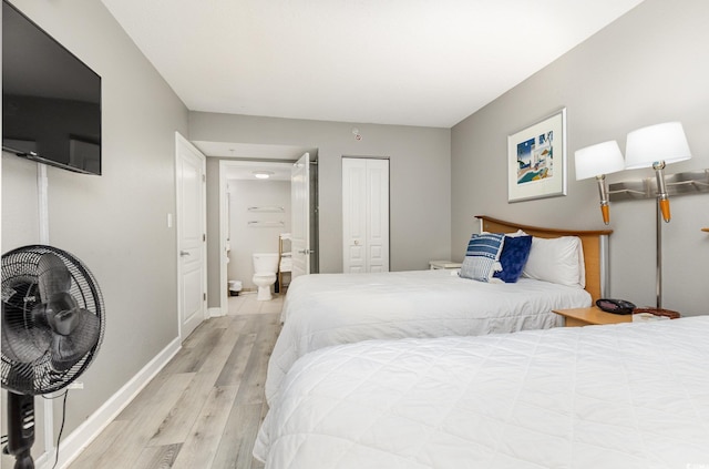 bedroom with connected bathroom, light hardwood / wood-style floors, and a closet