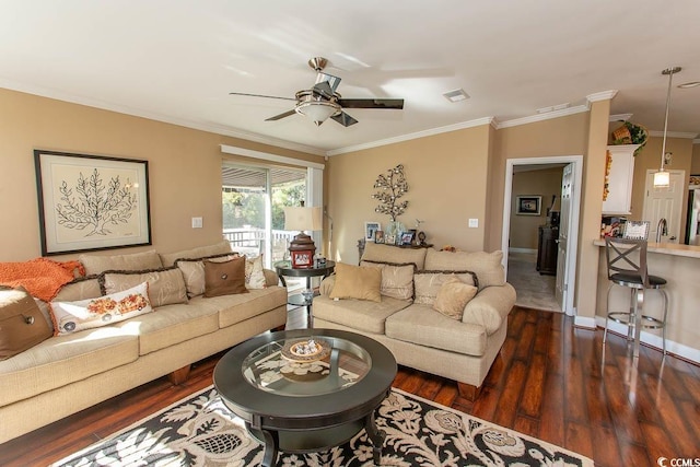 living room featuring dark wood-type flooring, ceiling fan, and crown molding