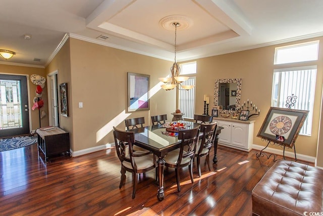 dining room with a chandelier, ornamental molding, a raised ceiling, and dark wood-type flooring