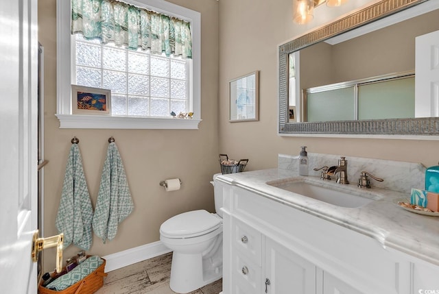 bathroom featuring walk in shower, vanity, and toilet