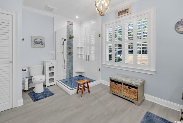 bathroom featuring a shower with door, an inviting chandelier, toilet, ornamental molding, and wood-type flooring